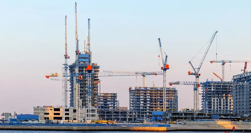 Multiple tower cranes over several high-rise apartment buildings under construction